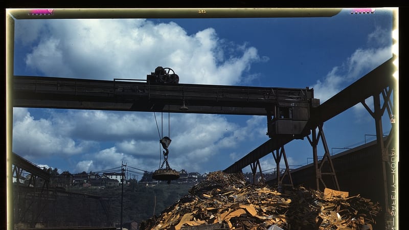 Overhead magnet crane loading scrap metal into rail cars
