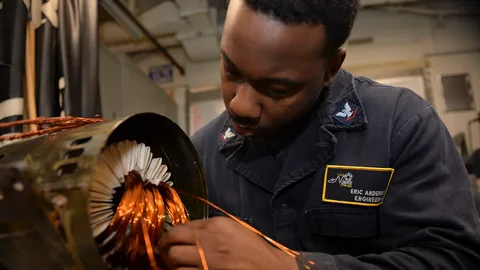 Technician rewinding the copper coils of an electric motor